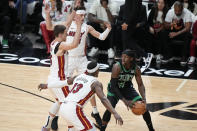 Boston Celtics guard Jrue Holiday (4) looks for an opening past Miami Heat center Bam Adebayo (13) forward Nikola Jovic, far left, and guard Tyler Herro, rear, during the first half of Game 3 of an NBA basketball first-round playoff series, Saturday, April 27, 2024, in Miami. (AP Photo/Wilfredo Lee)