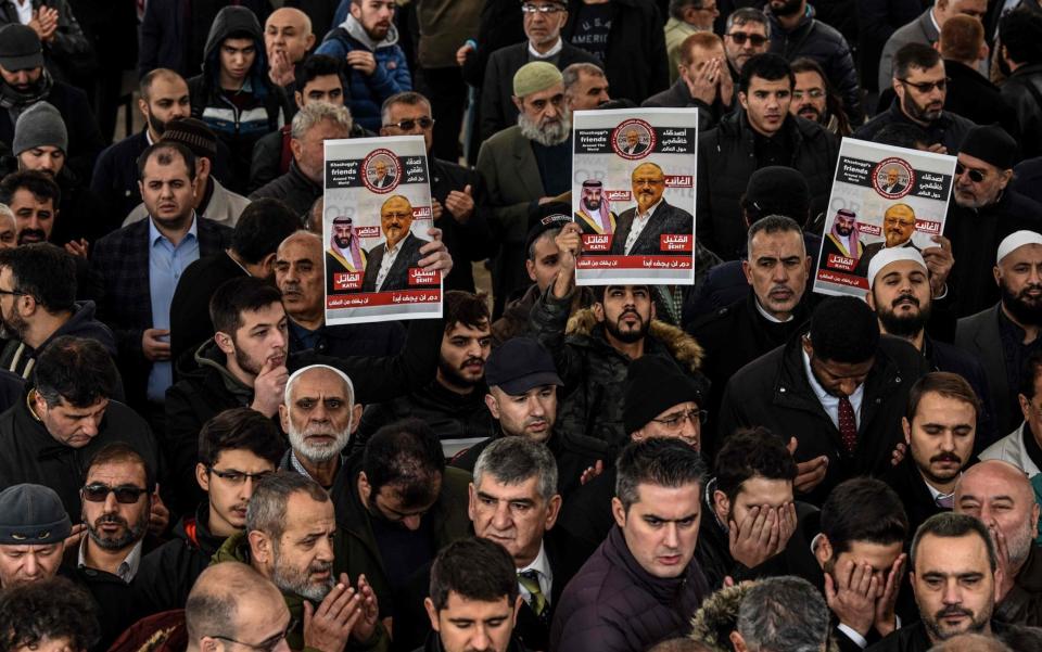 Mourners hold images of Jamal Khashoggi during symbolic funeral prayers in Istanbul - AFP
