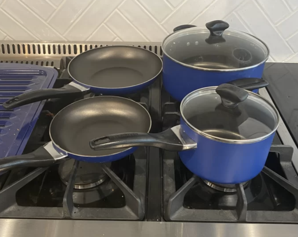 the set of cookware on a reviewer's stove in the dark blue color