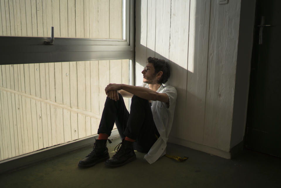 In this photo taken on Dec.15, 2019 Vincent Achour, a psychiatry intern on strike sits by a window at the intern residency at Marseille's La Timone hospital in Marseille, southern France. In a hospital in Marseille, student doctors are holding an exceptional, open-ended strike to demand a better future. France’s vaunted public hospital system is increasingly stretched to its limits after years of cost cuts, and the interns at La Timone - one of the country’s biggest hospitals - say their internships are failing to prepare them as medical professionals. Instead, the doctors-in-training are being used to fill the gaps. (AP Photo/Daniel Cole)