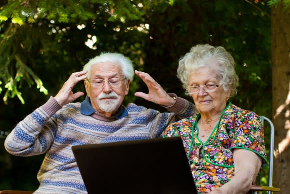 Couple reading news on a laptop