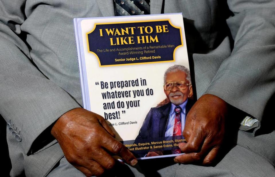 Judge L. Clifford Davis holds a book, released by local attorney Bobbie Edmonds, about this life and legacy.