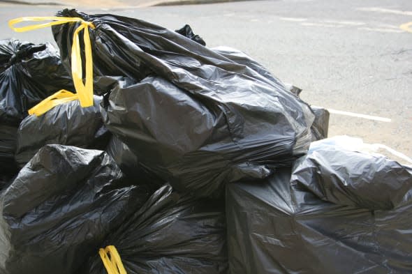 environmental issues, recycling black bin liners full of rubbish on the street