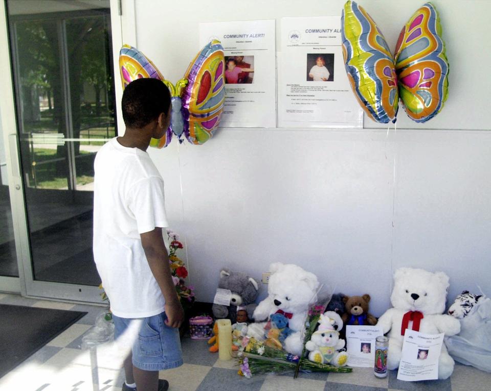 Quamine McClaie, 11, looks at posters of missing sisters Tionda Bradley, 10, and Diamond, left, 3, posted in the lobby of the girls apartment building in Chicago Wednesday, July 11, 2001.