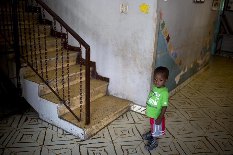 An orphan boy stands next to a staircase while looking out from the Nest of Hope orphanage in Port-au-Prince, Haiti on Thursday, June 28, 2018. A new program is cited by Haitian and foreign experts as evidence of the government's determination to modernize and strengthen an array of child-oriented policies and practices _ and lessen reliance on foreign-based charities and mission groups. (AP Photo/Dieu Nalio Chery)