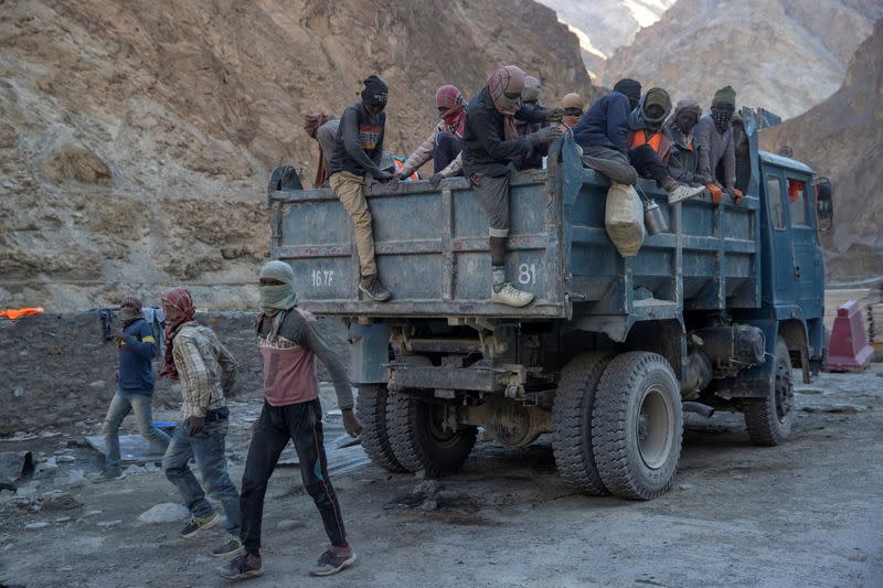 Workers from Border Roads Organisation get off a truck after arriving at their living quarters on an under construction highway in the Ladakh region