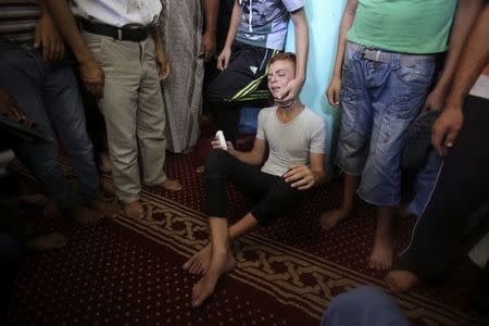 A Palestinian reacts during the funeral of three senior Hamas commanders, who were killed in an Israeli air strike, at a mosque in Rafah in the southern Gaza Strip August 21, 2014. REUTERS/Ibraheem Abu Mustafa