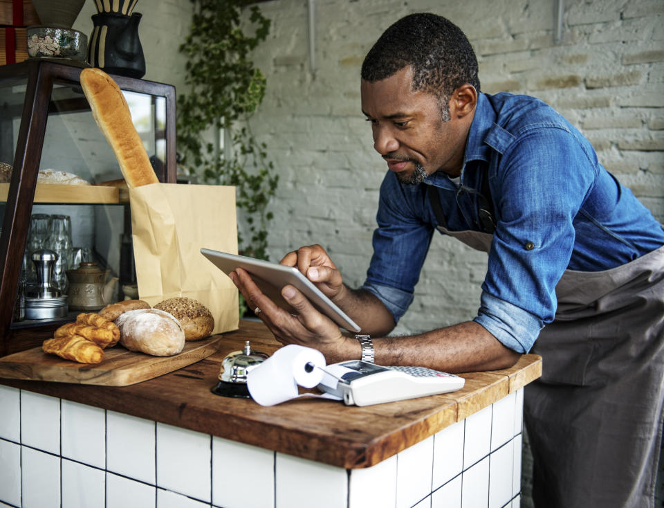 A cafe owner orders supplies on a tablet device.