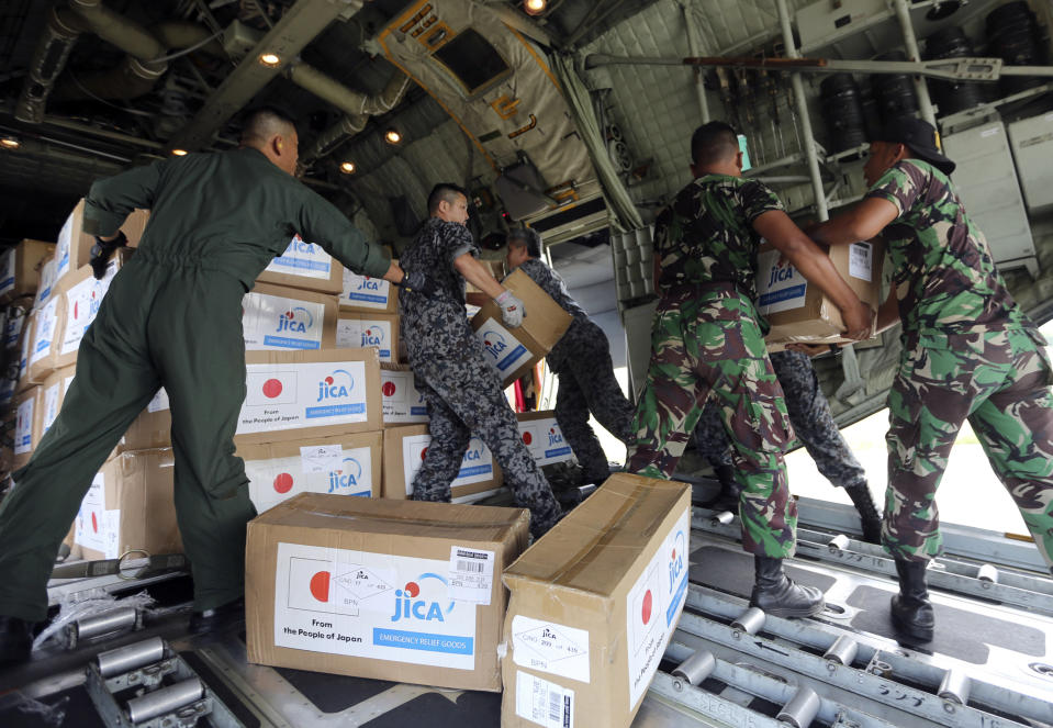 Indonesian and Japanese military personnel unload relief aid from a Japan Air Force cargo plane at the Mutiara Sis Al-Jufri airport in Palu, Central Sulawesi, Indonesia, Saturday, Oct. 6, 2018. A 7.5 magnitude earthquake rocked the city on Sept. 28, triggering a tsunami and mud slides that killed a large number of people and displaced tens of thousands others. (AP Photo/Tatan Syuflana)