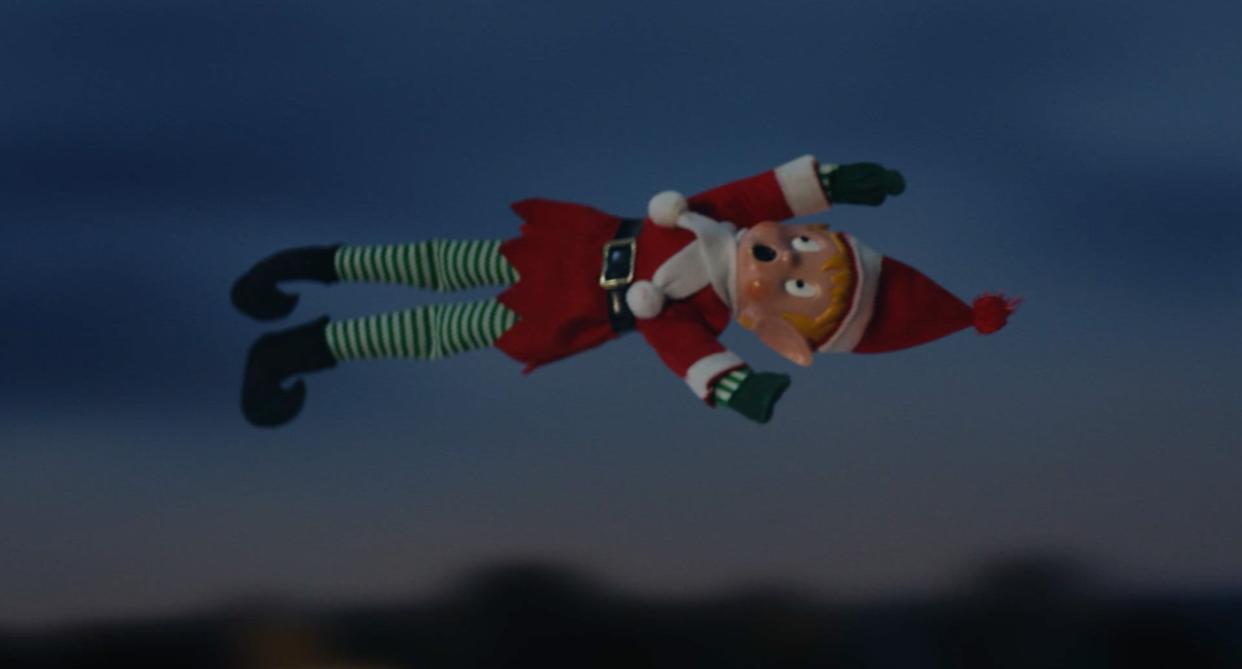 A toy elf appears to be screaming as it flies over houses, and is about to land in Hannah Waddingham's driveway in M&S new Christmas advert. (M&S)