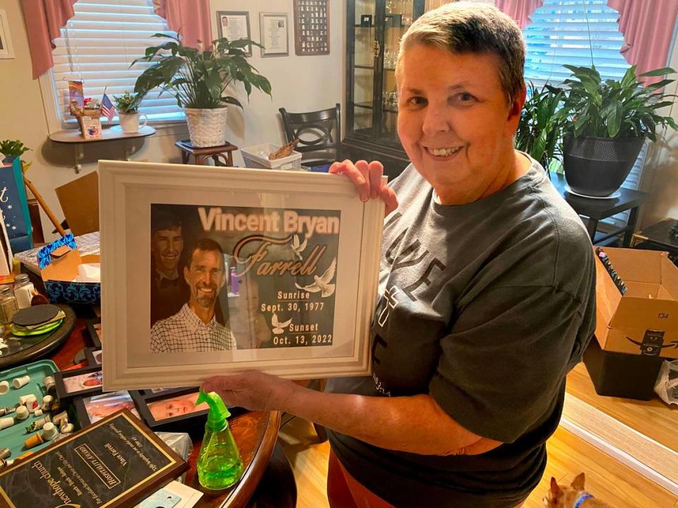 Patricia Farrell of Durham holds up memorial plaque of her late son, Vincent, who died while at work at Wolfspeed.