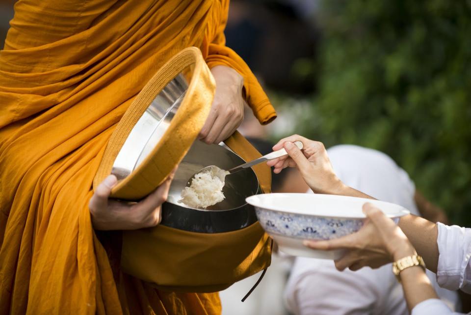 Theravada monks collect alms from lay Buddhists during their morning rounds. <a href="https://www.gettyimages.com/detail/photo/people-tak-bat-or-give-alm-to-monks-by-putting-royalty-free-image/1150323283?phrase=theravada+monks&adppopup=true" rel="nofollow noopener" target="_blank" data-ylk="slk:Sunphol Sorakul/Moment via Getty Images;elm:context_link;itc:0;sec:content-canvas" class="link ">Sunphol Sorakul/Moment via Getty Images</a>