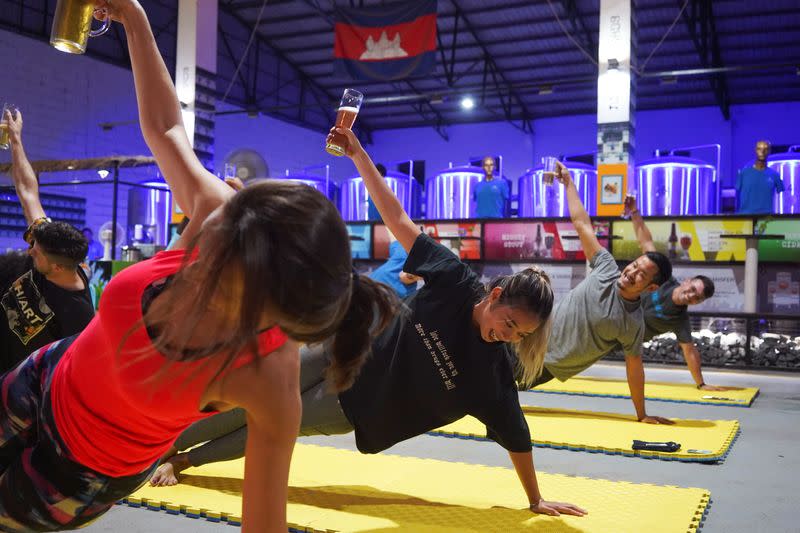 People participate in a beer yoga session, as the country eases COVID-19 restrictions, at a craft brewery in Phnom Penh