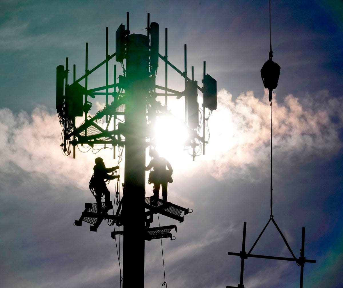 A crew with Tower Warriors Construction, out of Plainfield, Illinois work on installing cellular equipment for Dish Network Wireless on a cell communications tower.