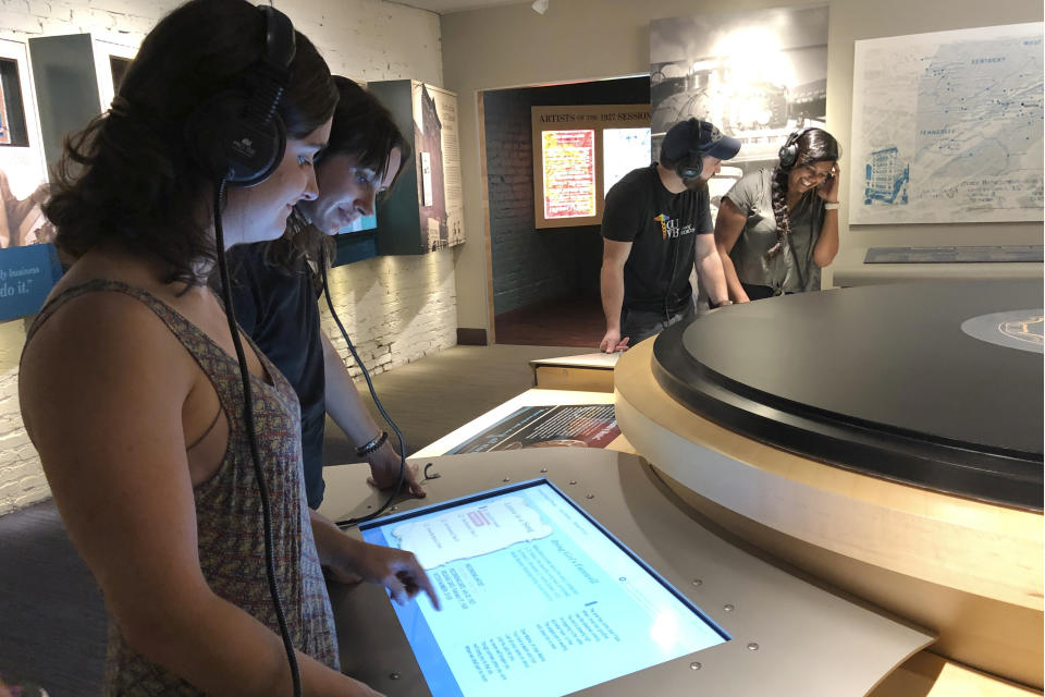 In this June 26, 2019 photo, Katie Dickerson and Kyrra Engle listening to an early country music recording at the Birthplace of Country Music Museum in Bristol, Va. Ten medical students were on a tour of the city organized by a medical school with the aim of luring them to practice in rural communities facing health care shortages after graduation. (AP Photo/Sudhin Thanawala)