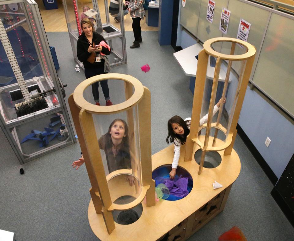 Children explore a device which pushes air through cylinders pushing light material through and into the air at the Children's Museum of New Hampshire Nov. 15, 2023. The facility celebrates 40 years of helping children learn with play.