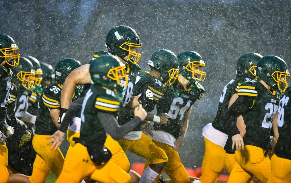 Sauk Rapids-Rice players take the field for their game against Cambridge-Isanti as heavy rain falls Friday, Sept. 23, 2022, in Sauk Rapids. 