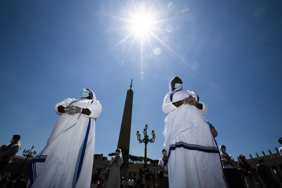 Nuns and faithful gather in St. Peter's Square at the Vatican, Sunday, May 31, 2020. Pope Francis has cheerfully greeted people in St. Peter’s Square on Sunday, as he resumed his practice of speaking to the faithful there for the first time since lockdown began in Italy and at the Vatican in early March. Instead of the tens of thousands of people who might have turned out on a similarly brilliantly sunny day like this Sunday, in pre-pandemic times, perhaps a few hundred came to the square, standing well apart from others or in small family groups. (AP Photo/Alessandra Tarantino)