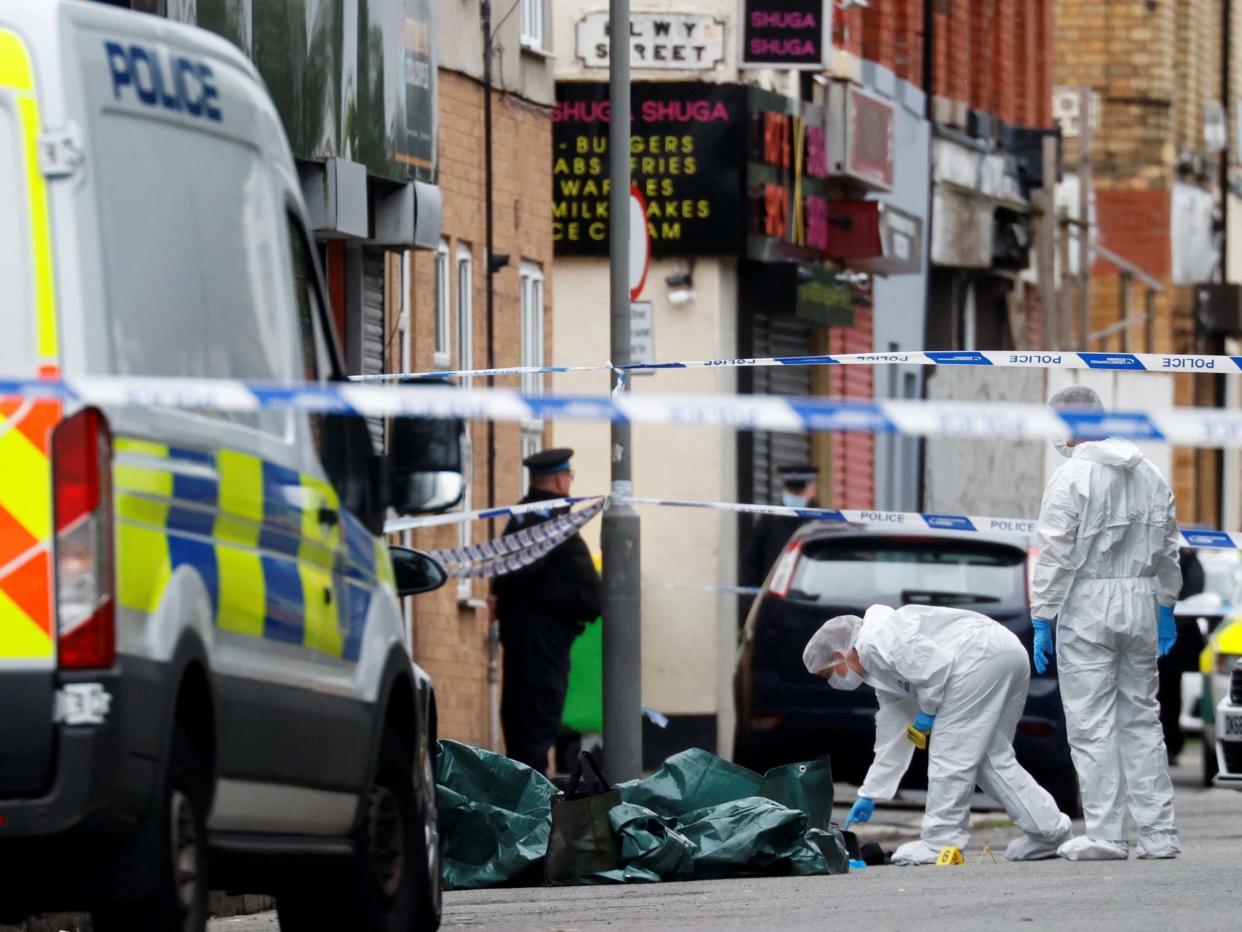 Police officers examine the scene in Toxteth, Liverpool, where a woman was shot by police on 9 July 2020: Phil Noble/Reuters