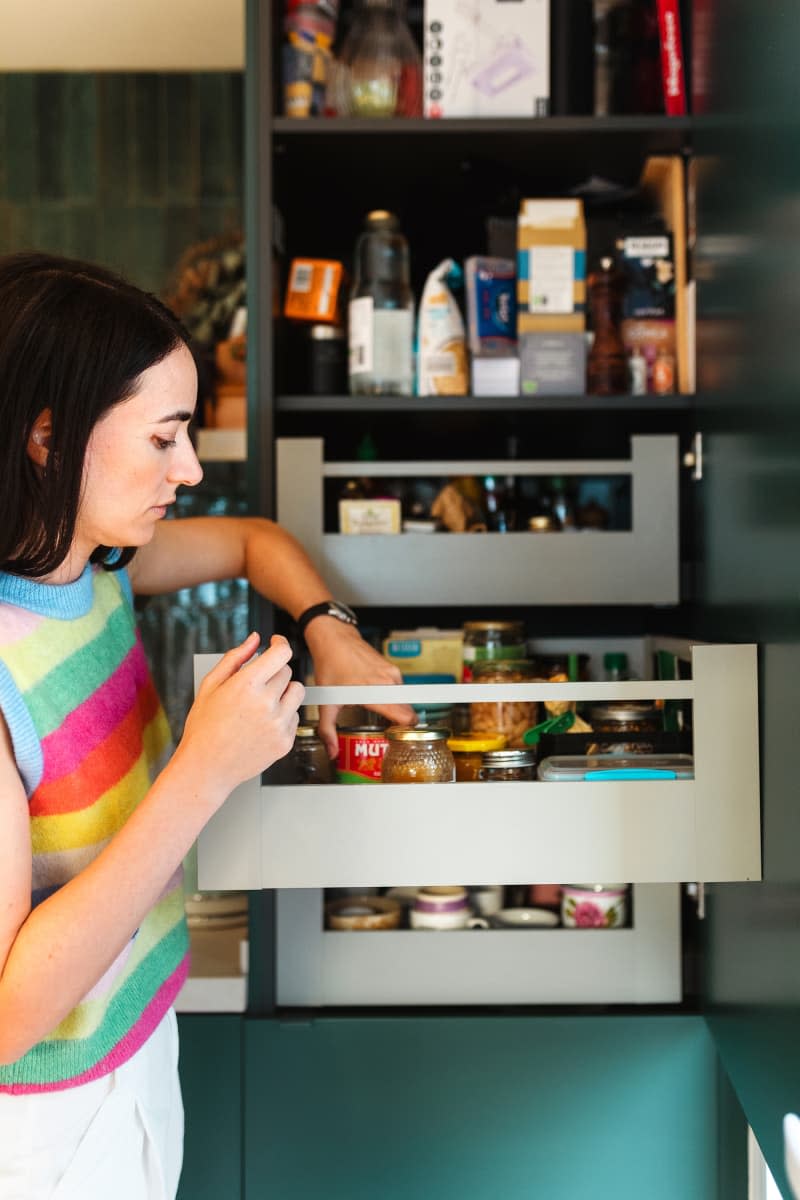 A dweller using s shelf that was built into the kitchen walls.