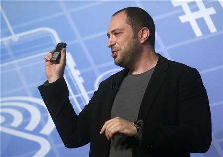 WhatsApp Chief Executive Officer and co-founder Jan Koum holds up a mobile phone as he delivers a keynote speech at the Mobile World Congress in Barcelona February 24, 2014. REUTERS/Albert Gea