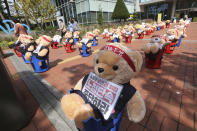 Teddy bears are displayed to protest against a crackdown on illegal street vendors, in front of the Mapo ward office in Seoul, South Korea, Thursday, Sept. 24, 2020. Street vendors replaced protestors with teddy bears to avoid the violation of an ongoing ban on rallies with more than 10 people amid the coronavirus pandemic. The signs read: "Stop crackdown." (AP Photo/Ahn Young-joon)