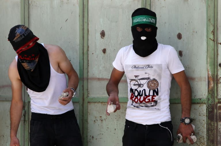 Palestinians hold stones during clashes with Israeli security forces on July 31, 2015 in the Israeli-controlled area called H2, in the West Bank town of Hebron