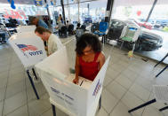 Leeah Durkee, 30, casts her ballot in the US presidential elections in the polling place of Sunrise Ford car dealership on November 6, 2012 in Los Angeles, California. Californians will cast ballots in dozens of tight races including Gov. Jerry Brown's tax plan, abolishing the death penalty, easing the state's strict 'three strikes' sentencing law and also in the Presidential race between Democratic President Barack Obama and Republican candidate Mitt Romney. (Photo by Kevork Djansezian/Getty Images)