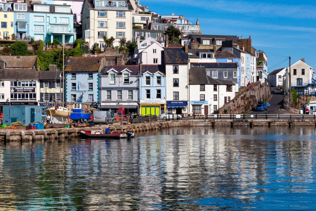 Brixham Harbour, Devon, England, UK: scenic view of bright relictions on a sunny day