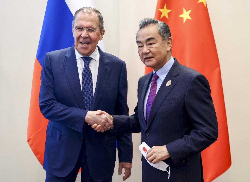 In this handout photo released by Russian Foreign Ministry Press Service, Russian Foreign Minister Sergey Lavrov, left, shakes hands with Chinese Foreign Minister Wang Yi during their bilateral meeting ahead of the G20 Foreign Ministers' Meeting in Nusa Dua, Bali, Indonesia, Thursday, July 7, 2022. (Russian Foreign Ministry Press Service via AP)