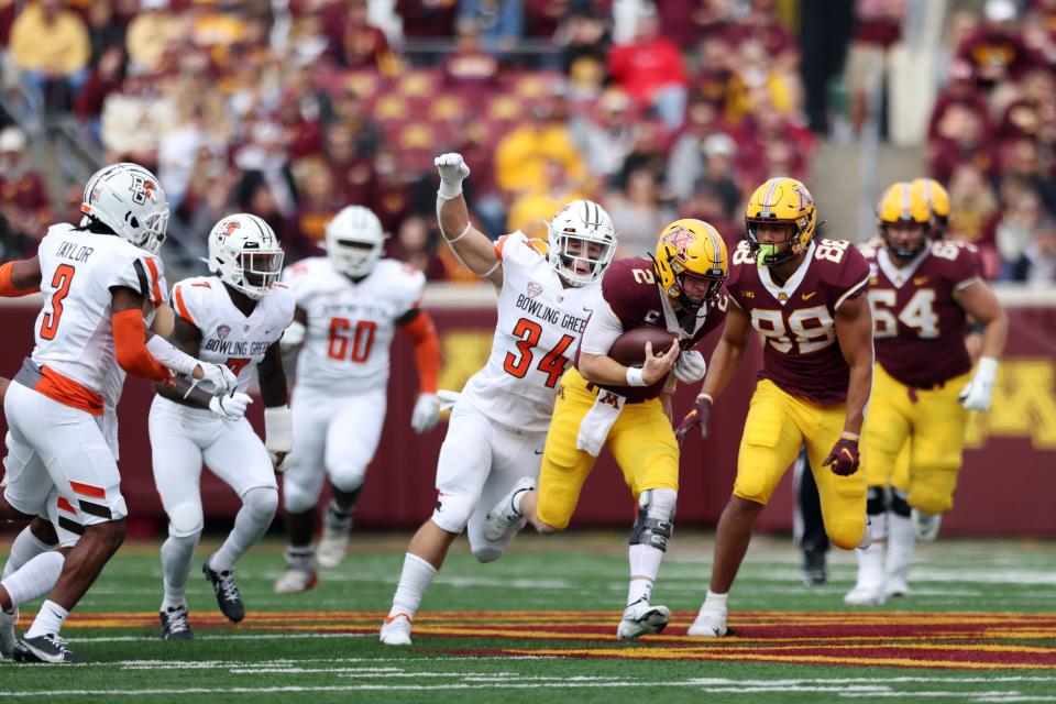 Minnesota quarterback Tanner Morgan (2) runs with the ball against Bowling Green linebacker Brock Horne (34) during the first half of an NCAA college football game Saturday, Sept. 25, 2021, in Minneapolis. (AP Photo/Stacy Bengs)