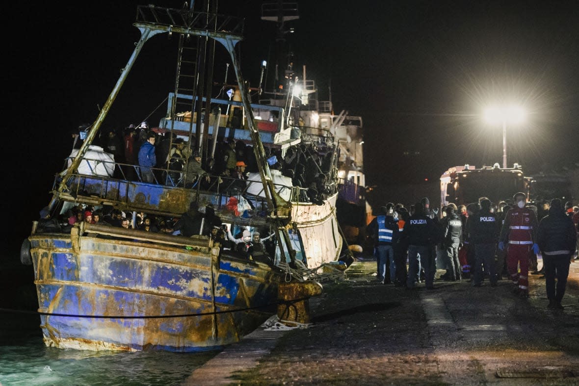 Police check a fishing boat with some 500 migrants in the southern Italian port of Crotone, early Saturday, March 11, 2023. (AP Photo/Valeria Ferraro)