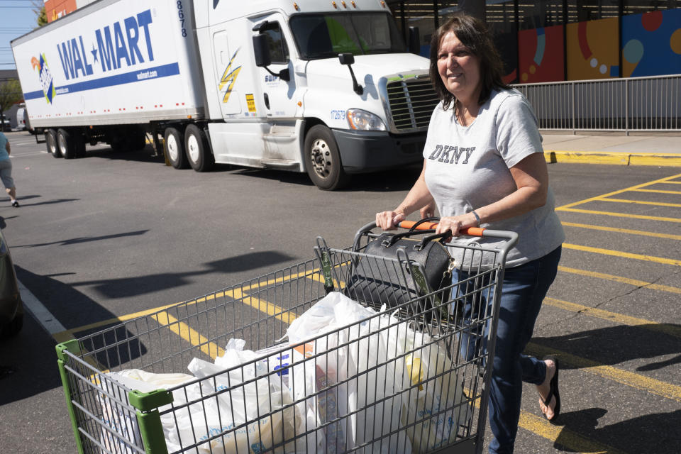 A customer pushes her cart into the parking lot after shopping at a Walmart Neighborhood Market, Wednesday, April 24, 2019, in Levittown, N.Y. The company has made the market into an artificial intelligence lab. (AP Photo/Mark Lennihan)