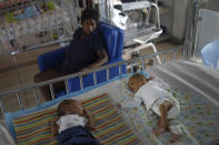 Twins rest on a bed at the Saint Damien Pediatric Hospital of Port-au-Prince, Haiti, Sunday, Oct. 24, 2021. Haiti's capital has been brought to the brink of exhaustion by fuel shortages and the capital's main pediatrics hospital says it has only three days of fuel left to run ventilators and medical equipment. (AP Photo/Matias Delacroix)