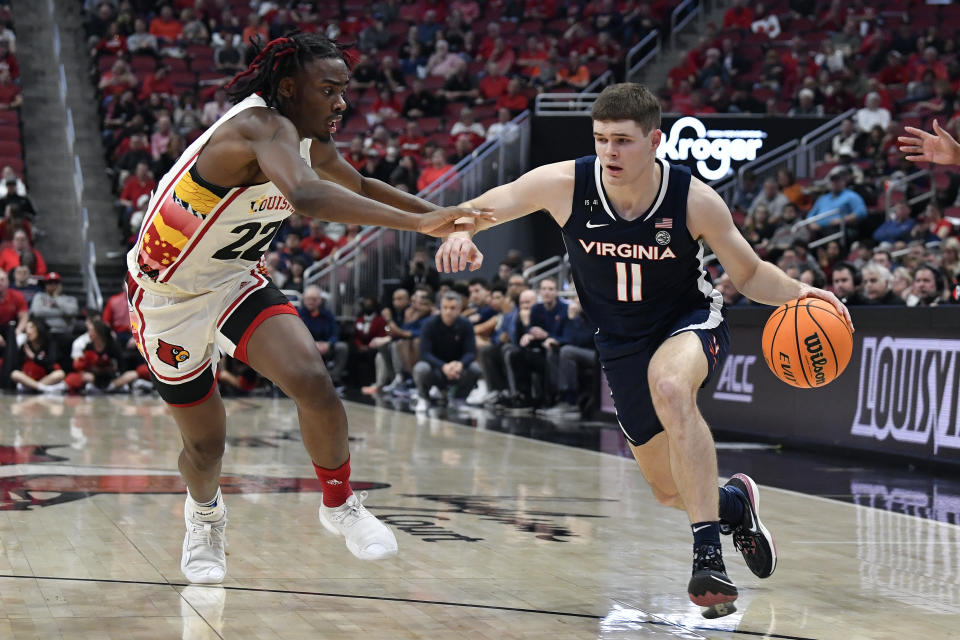 Virginia guard Isaac McKneely (11) drives to the basket against Louisville forward Kamari Lands (22) during the first half of an NCAA college basketball game in Louisville, Ky., Wednesday, Feb. 15, 2023. (AP Photo/Timothy D. Easley)