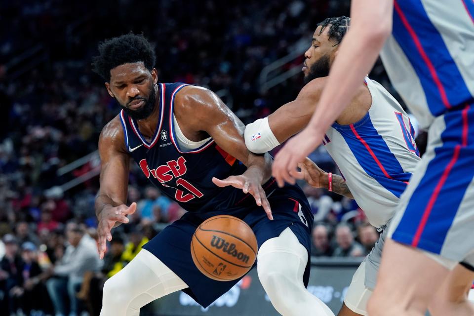 Philadelphia 76ers center Joel Embiid (21) is defended by Detroit Pistons forward Saddiq Bey during the first half on Thursday, March 31, 2022, at Little Caesars Arena in Detroit.