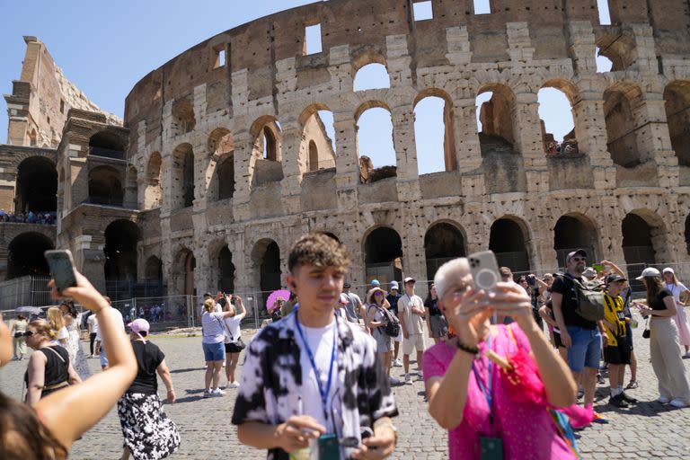 Turistas toman fotos del Coliseo en Roma, martes 27 de junio de 2023. El ministro de Cultura, Gennaro Sangiuliano, prometió hallar y castigar a un turista filmado cuando grababa su nombre y el de su novia en el muro del Coliseo, un delito que se castiga con multas abultadas.