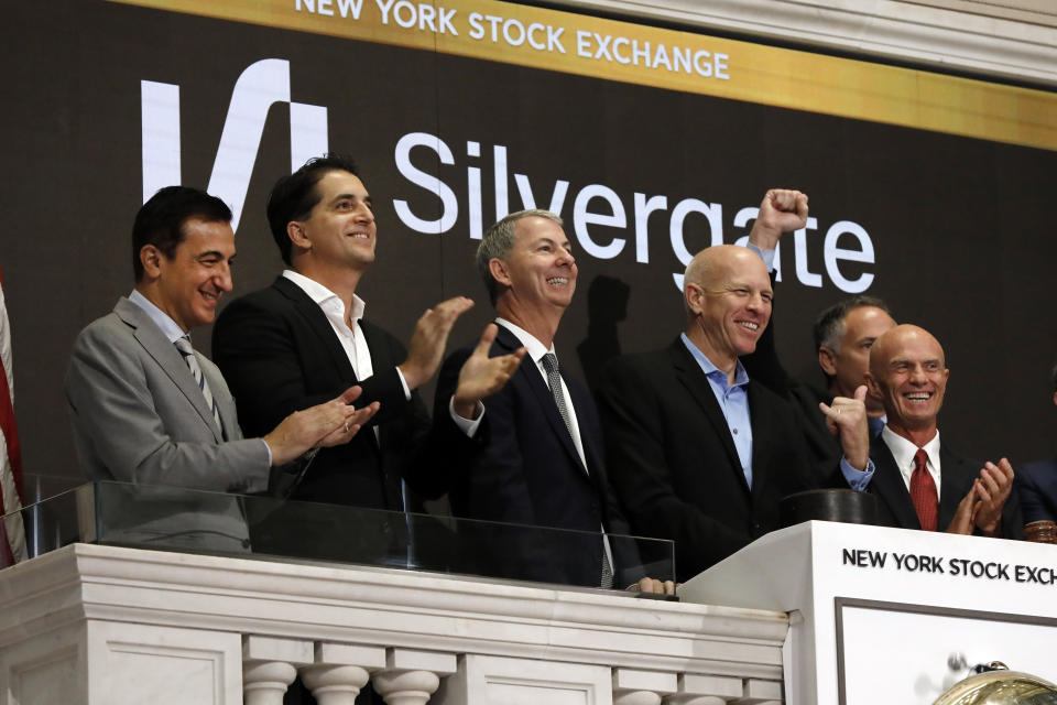 Alan Lane, CEO of Slivergate, second from right, is applauded as he rings the opening bell of the New York Stock Exchange ahead of his bank's IPO, Thursday, Nov. 7, 2019. (AP Photo/Richard Drew)