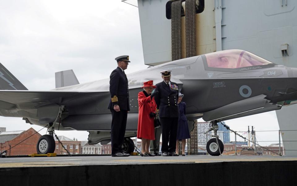 Captain Angus Essenhigh (CO of HMS Queen Elizabeth) and Commodore Steve Moorhouse (Commander of the Carrier Strike Group) hosted The Queen on the £3bn ship. May 22, 2021. - REUTERS