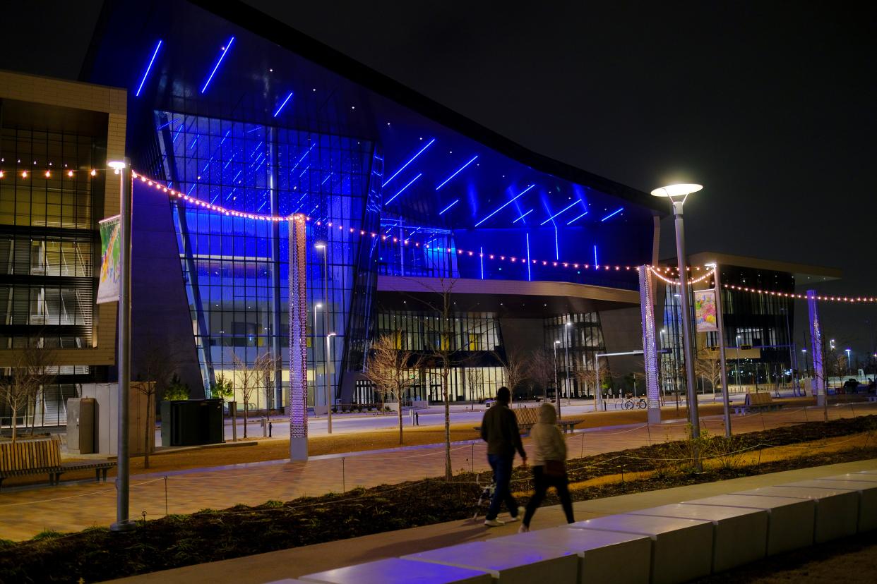 The new Convention Center provides a backdrop in 2021 as a couple walks along a sidewalk at Scissortail Park.