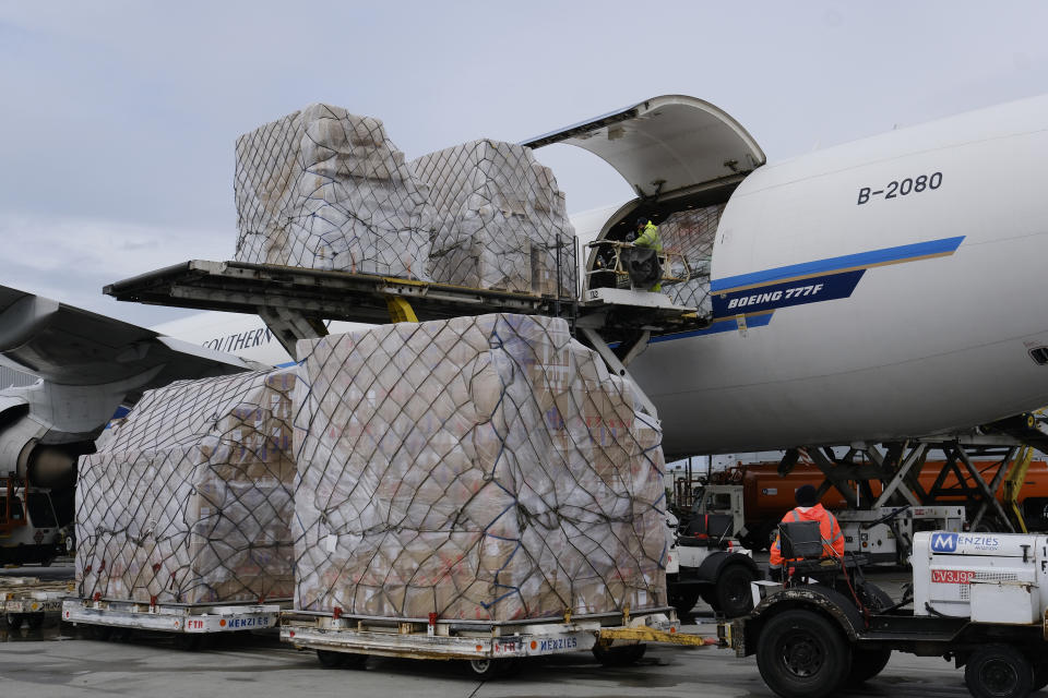 FILE - In this April 10, 2020, file photo, a ground crew at Los Angeles International Airport unload pallets of medical personal protective equipment from a China Southern cargo plane upon its arrival in Los Angeles. An Associated Press analysis shows states spent more than $7 billion this spring buying personal protective equipment like masks, gloves and gowns as well as vital medical devices like ventilators. (AP Photo/Richard Vogel, File)