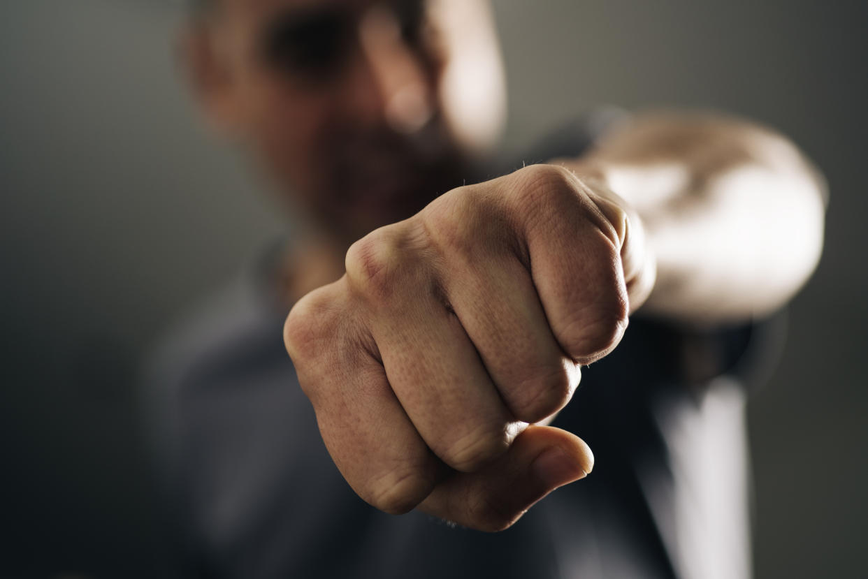 closeup of a young caucasian man throwing a punch to the observer, with a dramatic effect