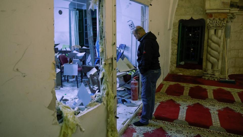 Un hombre mirando los destrozos en la mezquita de al-Aqsa