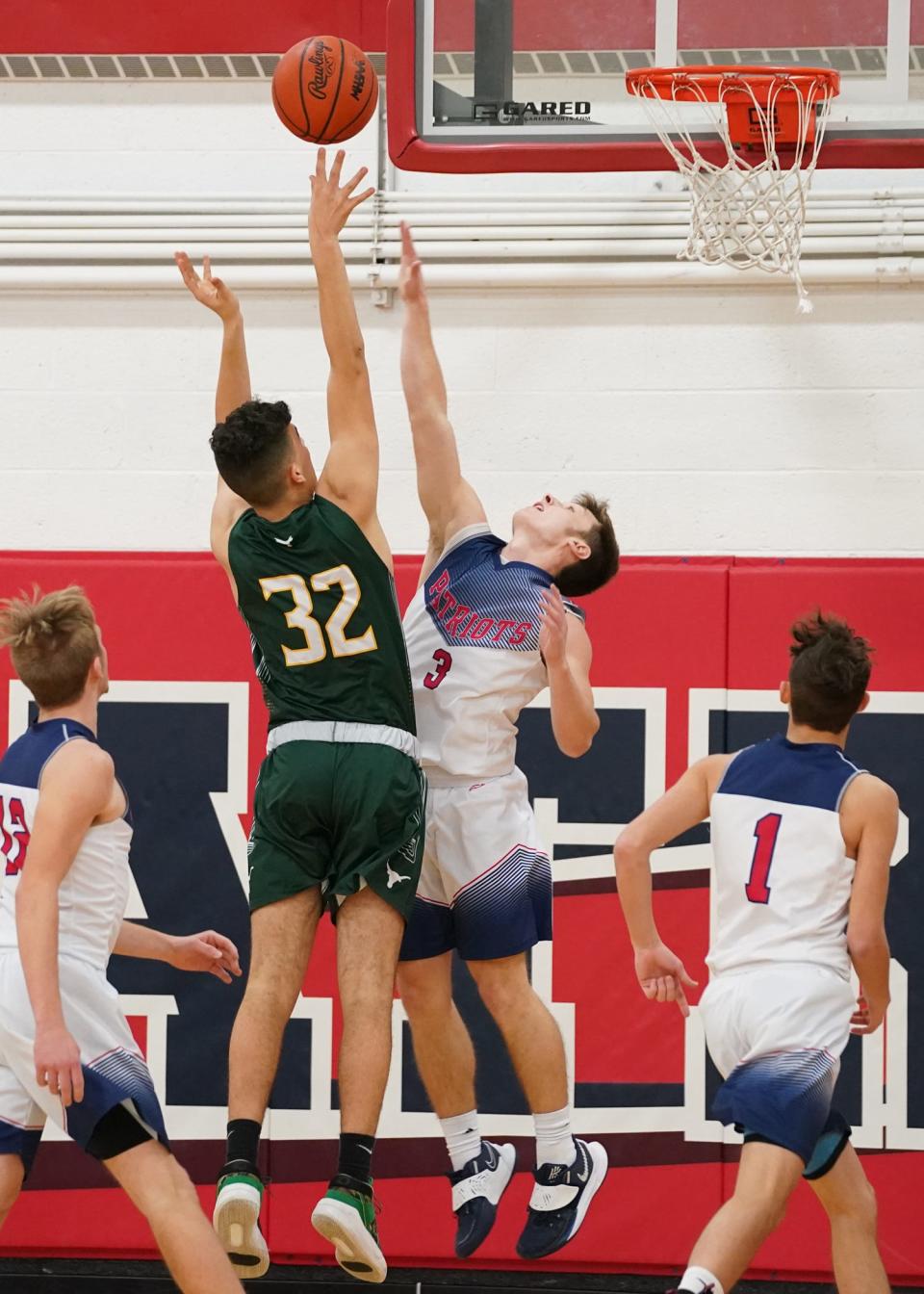 Sand Creek's Trevor Opel goes up for a shot while Britton Deerfield's Nico Johnson defends.