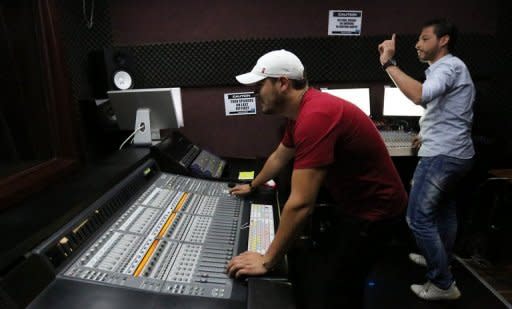 Libyan technicians work at the studio of Radio Zone, one of the hippest channels to hit the airwaves since the ouster of Moamer Kadhaf in the Libyan capital Tripoli. Radio Zone, which went on air for the first time in April, was financed by a group of friends, all new to the trade