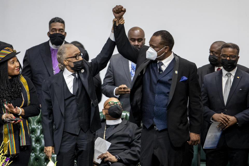 Rev. Al Sharpton, left, acknowledges Kent County Commissioner Robert S. Womack during the funeral for Patrick Lyoya at the Renaissance Church of God in Christ Family Life Center in Grand Rapids, Mich. on Friday, April 22, 2022. The Rev. Al Sharpton demanded that authorities publicly identify the Michigan officer who killed Patrick Lyoya, a Black man and native of Congo who was fatally shot in the back of the head after a struggle, saying at Lyoya's funeral Friday: “We want his name!" (Cory Morse/The Grand Rapids Press via AP)