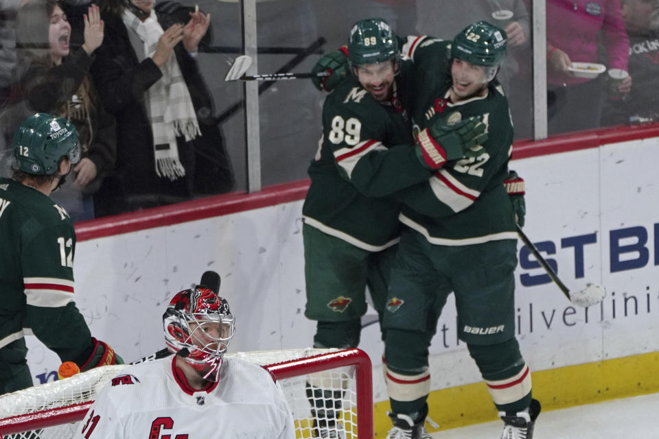 Minnesota Wild's Frederick Gaudreau (89) and Kevin Fiala (22) celebrate Gaudreau's goal against Carolina Hurricanes goalie Frederik Andersen, lower left, in the third period of an NHL hockey game, Saturday, Feb. 12, 2022, in St. Paul, Minn. (AP Photo/Jim Mone)