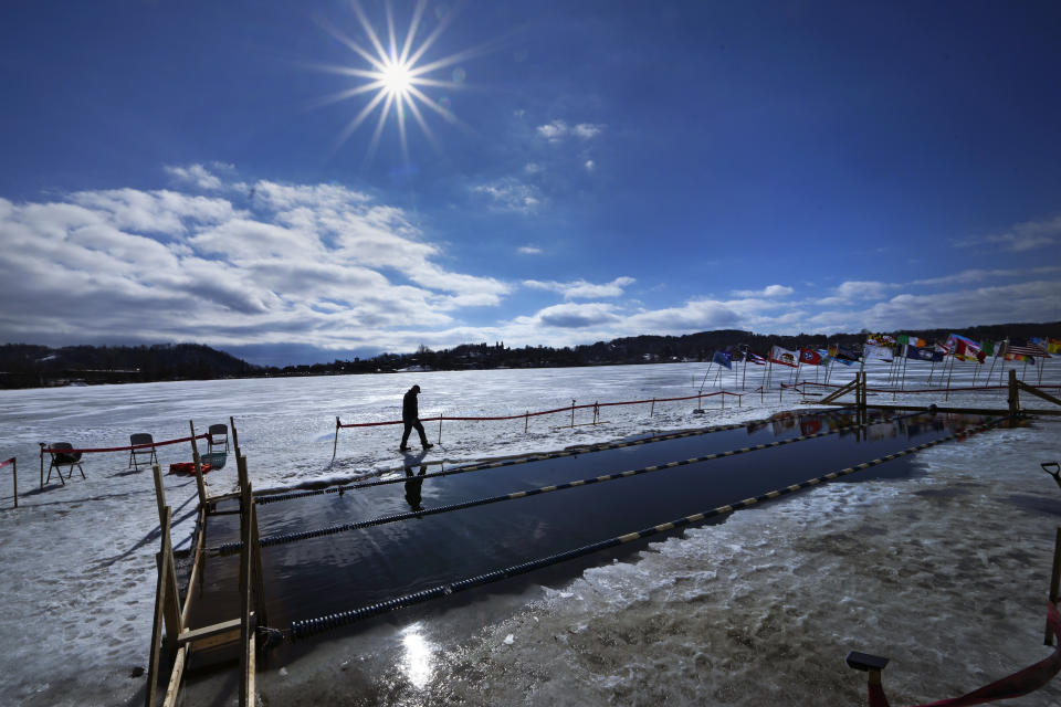 FILE - Greg O'Connor gives a safety check prior to the 200-meter freestyle competition in the winter swimming festival on frozen Lake Memphremagog, Feb. 23, 2024, in Newport, Vt. Federal meteorologists on Friday, March 8, have made it official: It's the warmest U.S. winter on record by far. (AP Photo/Charles Krupa, File)
