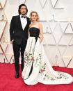 Adam Driver is wearing a Burberry tuxedo while his wife, Joanne Tucker, chose a vintage Oscar de la Renta gown. <em>[Photo: Getty]</em>