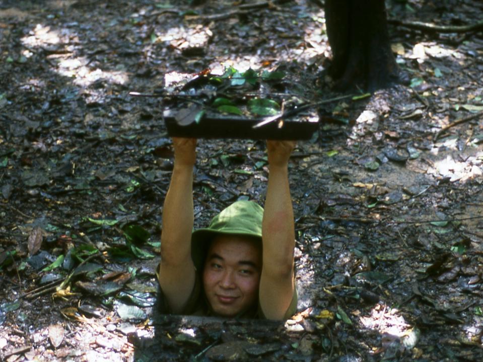 A man demonstrates how small the entrances were to some of the Cu Chi Tunnels